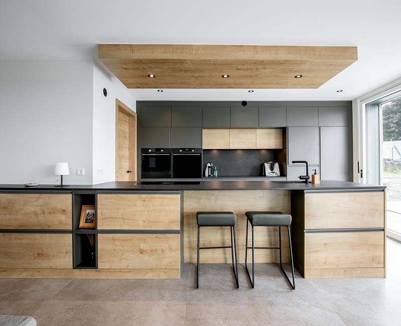 Stilvolle dunkle Küchenmöbel in Kombi mit gemasertem Holz